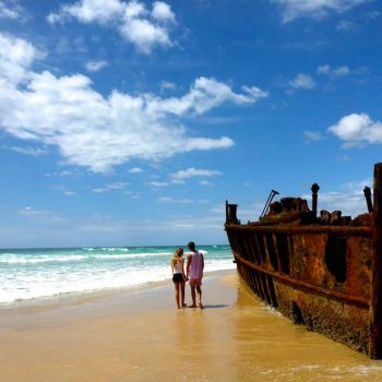 A man and a woman stand on a beach on Fraser Island