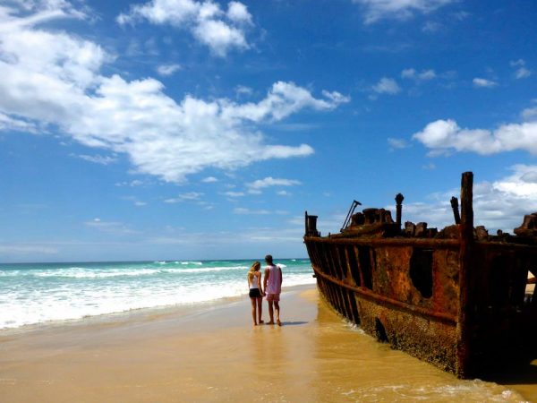 A man and a woman stand on a beach on Fraser Island