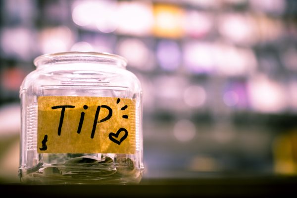 A tip jar sitting on a counter.