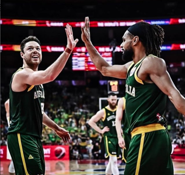 Two members of Australia's basketball team high five.